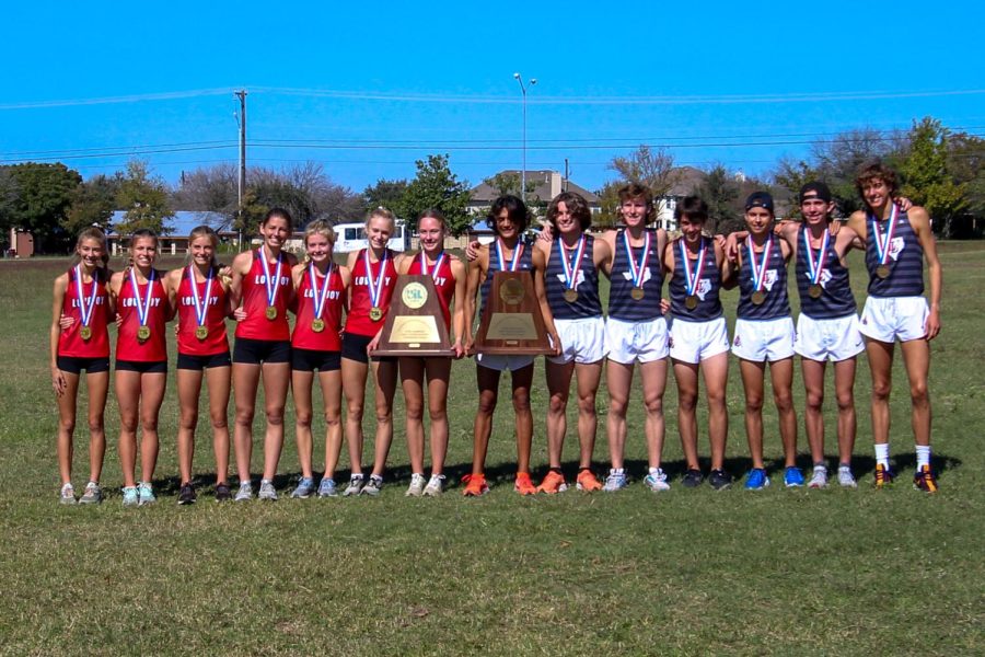 The boys and girls varsity cross country teams stand together holding their trophies. Both teams were able to fight their way onto the podium.