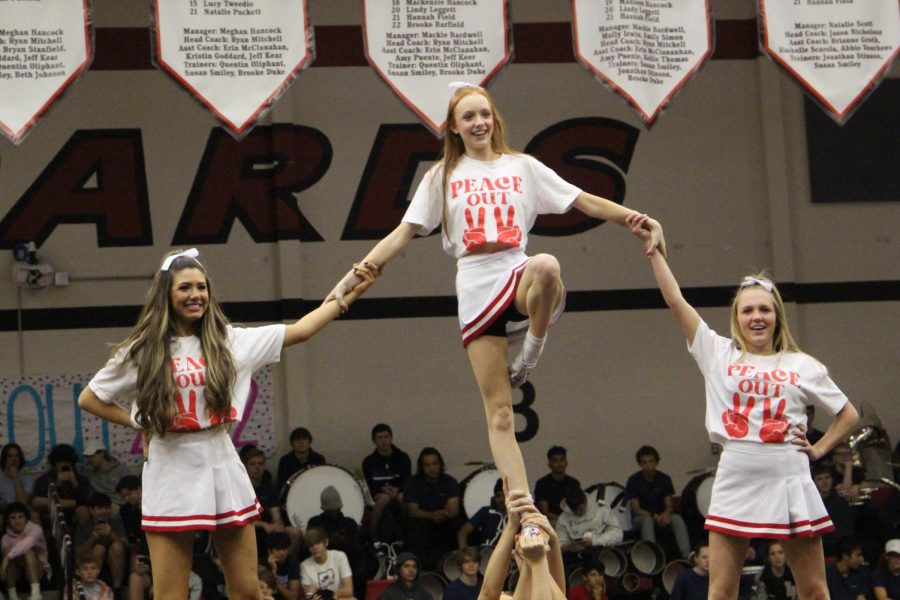 Seniors Ainsley Abernathy, Claire Traylor, and Ashley Ludlow do a pyramid for the senior cheer routine. Abrernathy is the cheer captain.