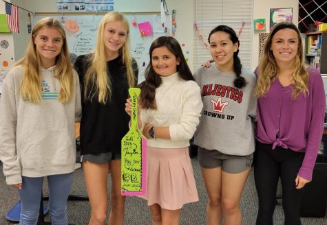 Sophomore Sara Morefield, sophomore Kailey Littlefield, freshman Taylor Barney, junior Isabella Zinn, and junior Amy Morefield hold the Best Buddies paddle. In the Best Buddies Organization, they have Big Sis and Little Sis pairings. In this photo, everyone is a big sis for Taylor Barney, who is the little sis.