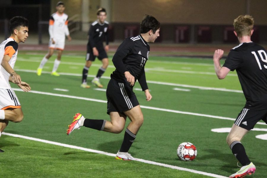 Senior forward no. 17 Nico Aguilar dribbles the ball down the field. Aguilar looks to pass to a teammate.
