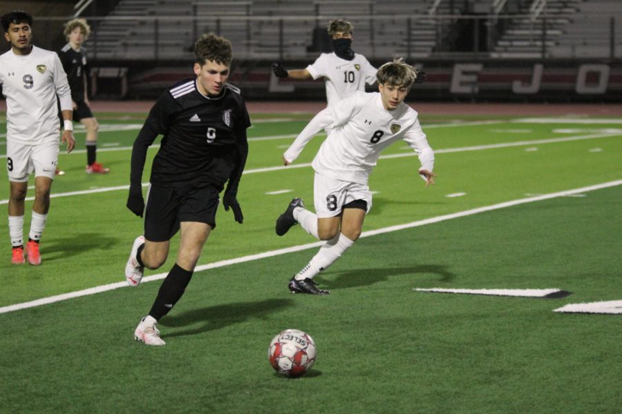 Junior forward no. 9 Adam Greenwald keeps the ball away from The Colonys sophomore midfielder no. 8 Hugo Castillon. Greenwald scored an assist at Tuesdays game.