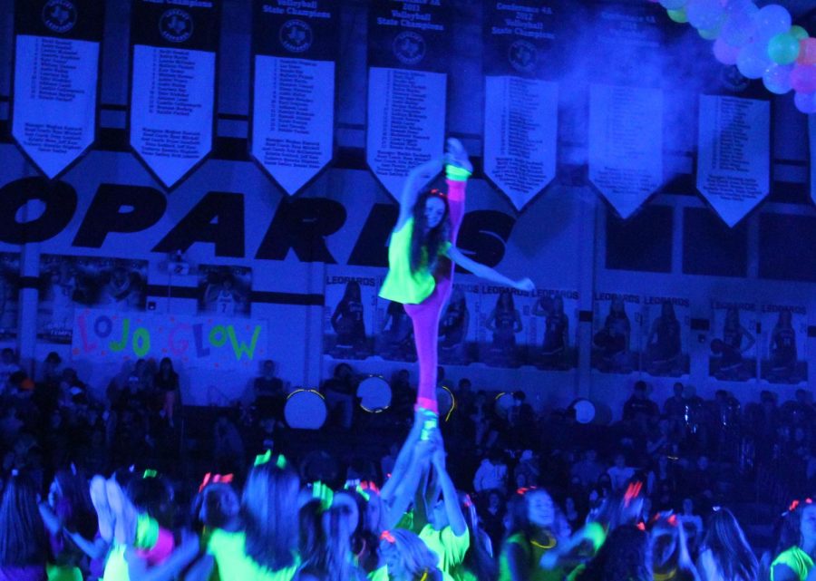 Senior Claire Traylor does a heel stretch during the cheer performance in the pep rally. Traylor participates in cheer outside of school. She is on Pathers at Cheer Athletics.