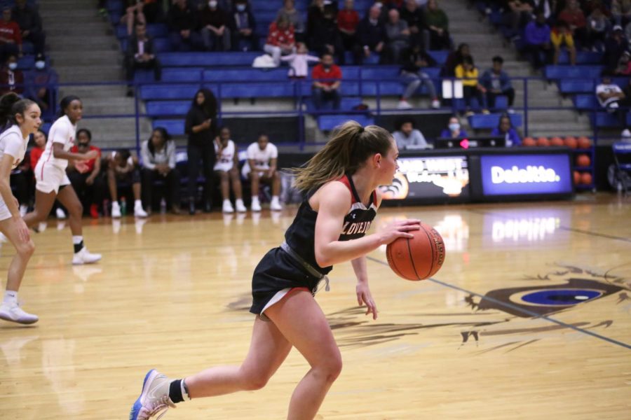Junior point guard no. 11 Chloe Schaeffer dribbles down the court to score. The Leopards first and last playoff game was against Frisco Liberty.