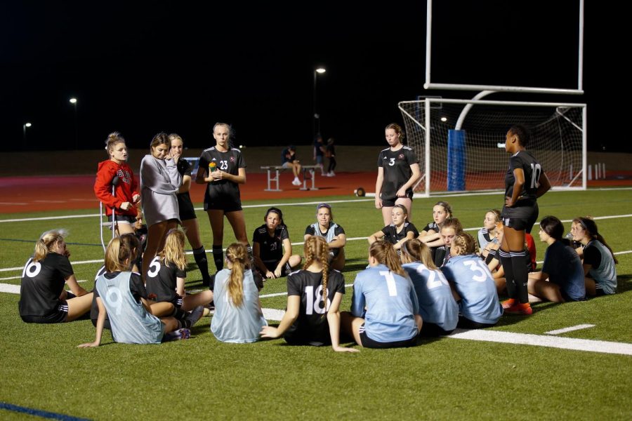 The girls soccer team talks about what they need to change in the second half. After the first half the score was 0-0.