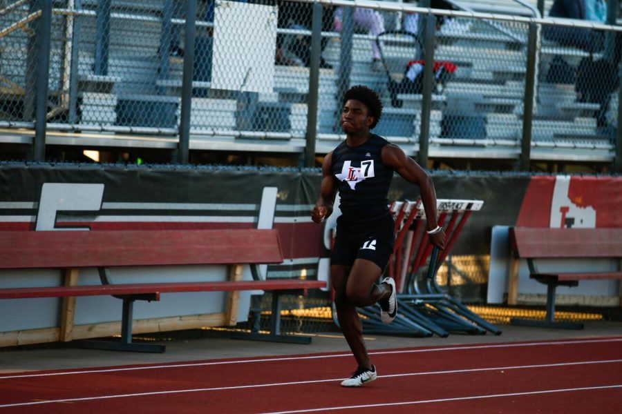 Junior Kyle Parker runs in the 4x100 relay. The relay won the event.
