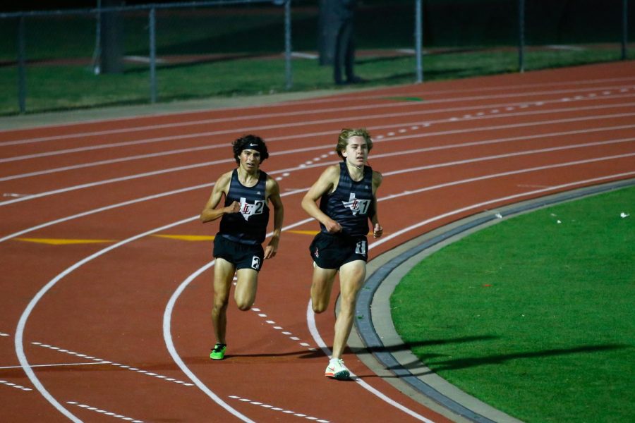 Sophomore Joe Bluestein and freshman Caden Gary battle for the lead in the final lap of the 1600 meter race. Bluestein won the event with a time of 4:28.00.