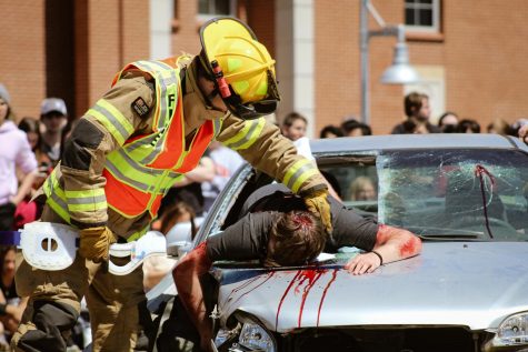 Fairview firefighter checks senior Griffin Peays pulse. The crash was staged to raise awareness of the impacts drunk driving leaves. 