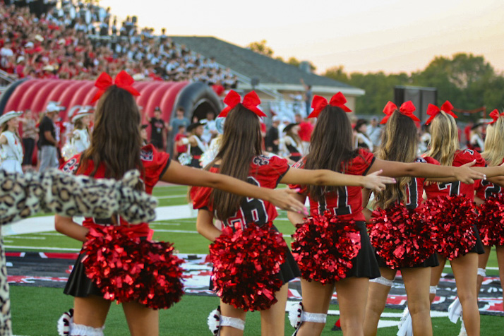 The varsity cheerleaders sing along to the Alma Mater. The game on Friday was the homecoming game.