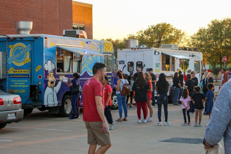 Parents and kids stand in line for the food trucks. A variety of food trucks along with Kona ice and a firetruck were at Leopard Friday.
