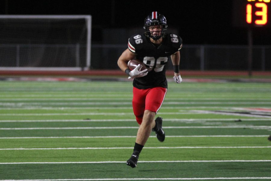 Junior tight end no. 86 Ridge Barker runs the ball into the end zone. The team has an overall record of 8-3.