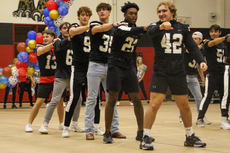 Senior football players perform a dance at the pep rally. Most of the dance was performed with their moms.