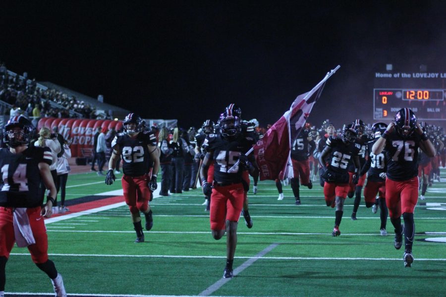 Senior outside linebacker no. 45 Dylan Kennedy carries the flag into the end zone. Lovejoy is ranked 3rd in the division.