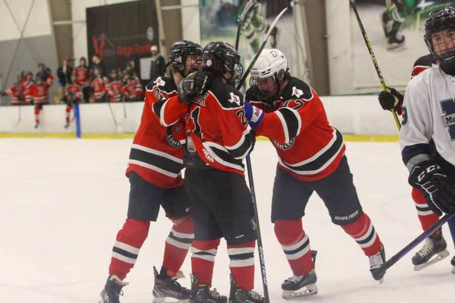 The Lovejoy hockey team celebrates after a goal. The goal was scored by senior Captain no. 21 Jake Schuler.