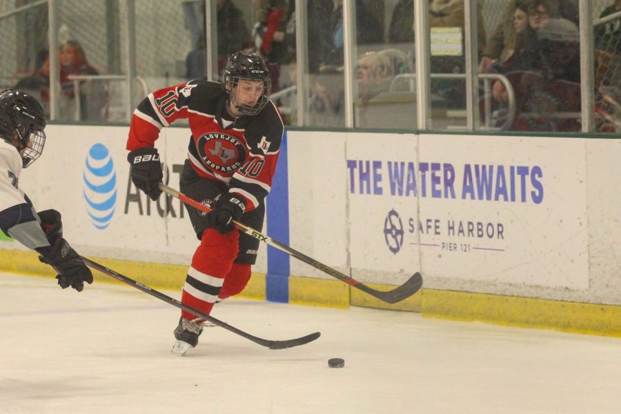 Junior no. 10 Davis Miller moves the puck down the ice. The team is competing in the State Championship this weekend.