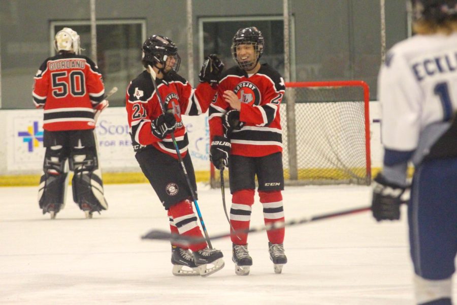 Senior no.21 Jake Schuler  congratulates senior no. 28 Samuel Chen. Chen scored two goals in the game. 