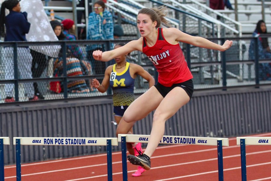 Junior Lauren Dolberry jumps a hurdle in the 300 meter varsity hurdle race. Dolberry placed fourth, scoring four points for the team.