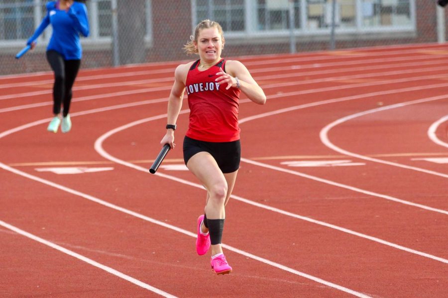 Senior Bella Landrum runs the 4x400 meter relay. The Varsity girls came in first place for the race and overall.