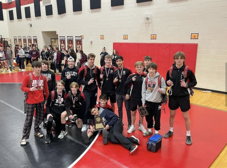The+wrestling+team+poses+for+a+picture+after+becoming+district+champions.+The+group+placed+second+overall+in+the+state+championship+meet.
