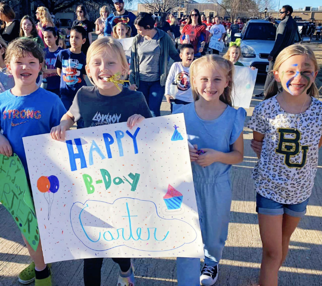 Elementary+students+made+signs+to+celebrate+Carter.+Community+members%2C+students%2C+high+school+athletics%2C+cheer%2C+the+Majestics+and+fine+arts+were+also+seen+marching+down+Stacy+Ridge+to+the+Dubois%E2%80%99+home.+