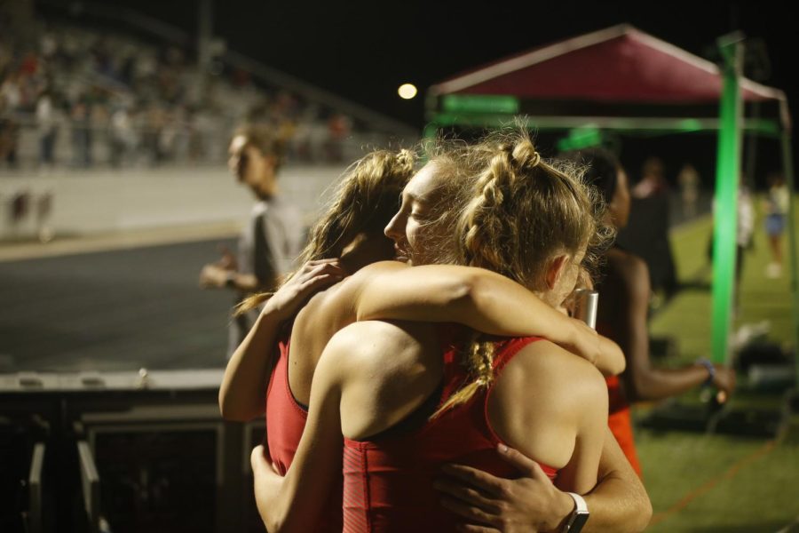 The JV girls 4x4 hugs at the end of their race. The relay was made up of freshman Cailee Horineck, junior Taylor Person, freshman Sophie Brooks, and freshman Addy McCaffity.