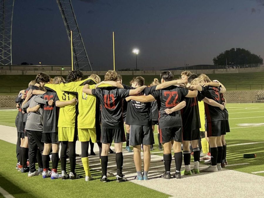 The+boys+soccer+team+huddles+pregame+before+their+first+round+matchup+against+Forney.+The+team+finished+the+season+12-3-5.