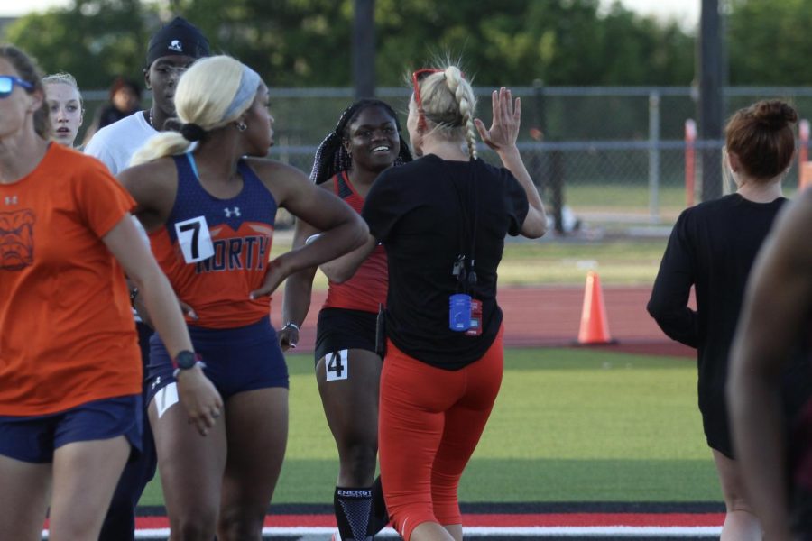 Head Girls Track and Field Coach, Carly Littlefield, high fives Senior Leila Ngapout after the Varsity Girls 100 meter race. Ngapout ran a personal best time of 11.64.