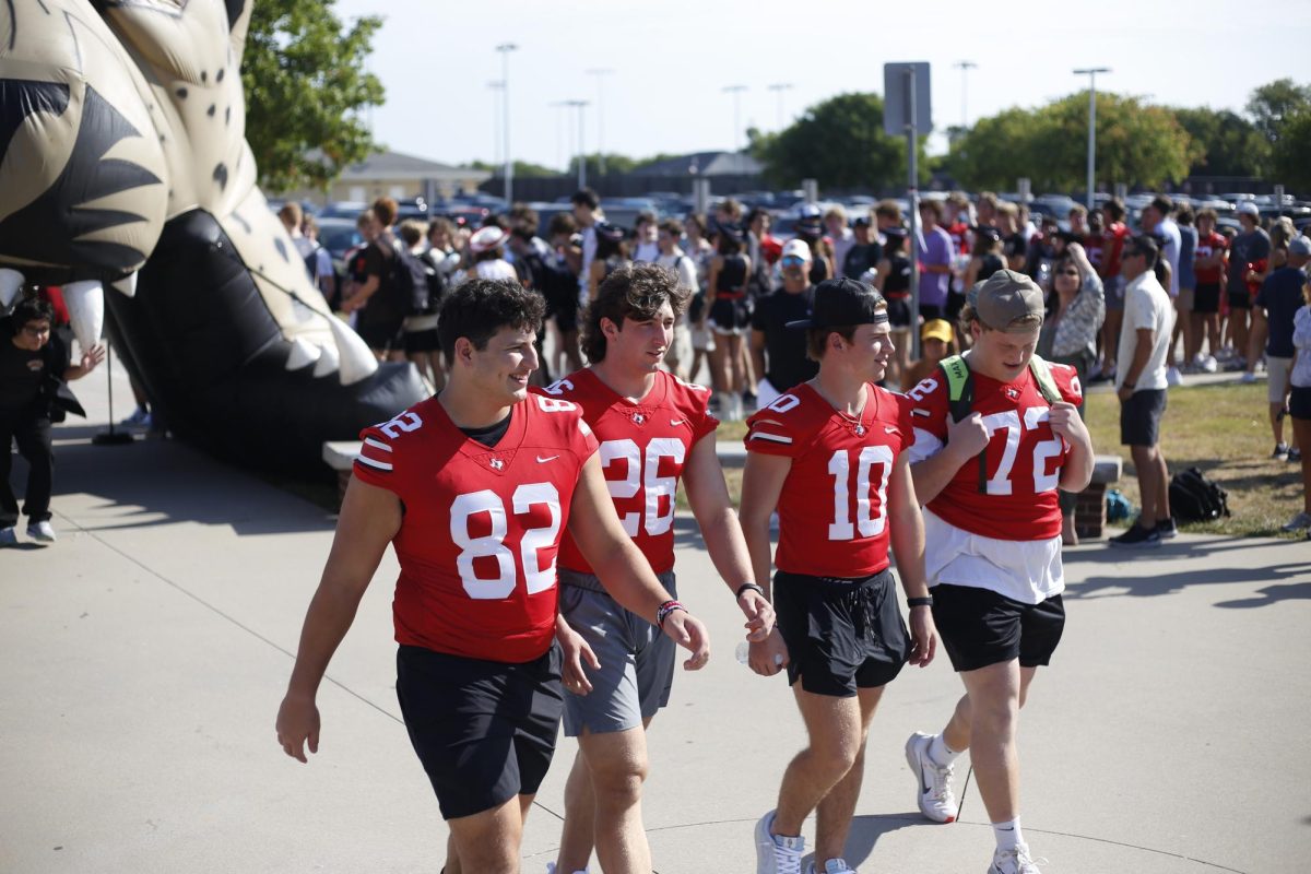 Seniors Nick Perez, Payton Pierce, Alexander Franklin, and Brandon Monroe walk through the blow up leopard head. The football team wore their jerseys for the walk.