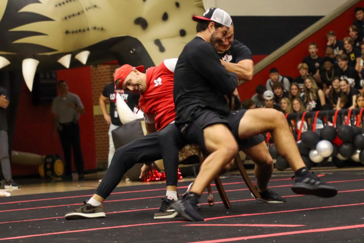 Football coaches Riley Donovan and Jake Mayfield fight over a chair in musical chairs. This was the final round.