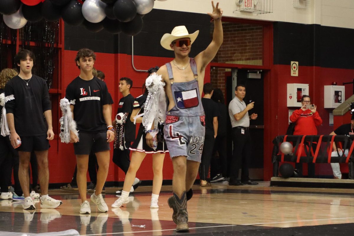 Senior Zane Evans waves to the crowd as he is announced a nominee for Most Spirited. Seniors Brooke Anderson and Grant Harlan won the title of Ms and Mr Spirited.