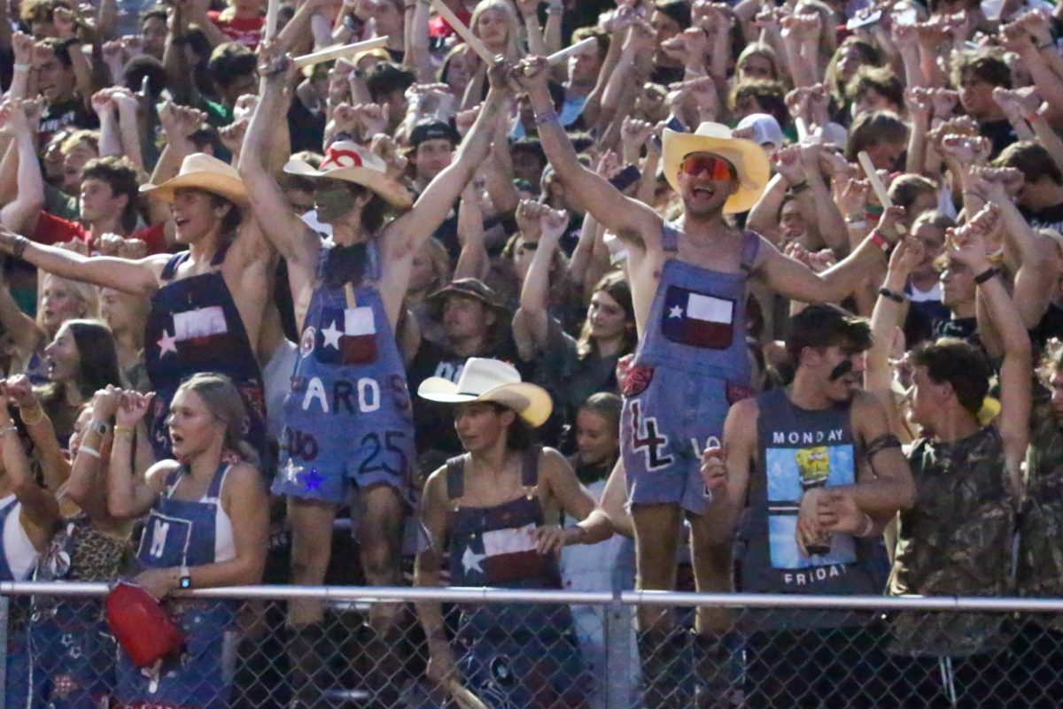 The dirty drumline links pinkies to prepare for kickoff. The drumline stands at the front of the student section for every home game.