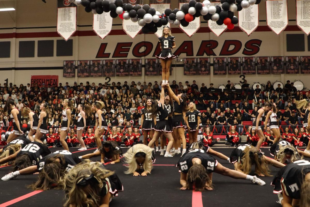 The cheer team performs a routine at the pep rally. Senior Ulani Phillips stands in the center in a stunt.