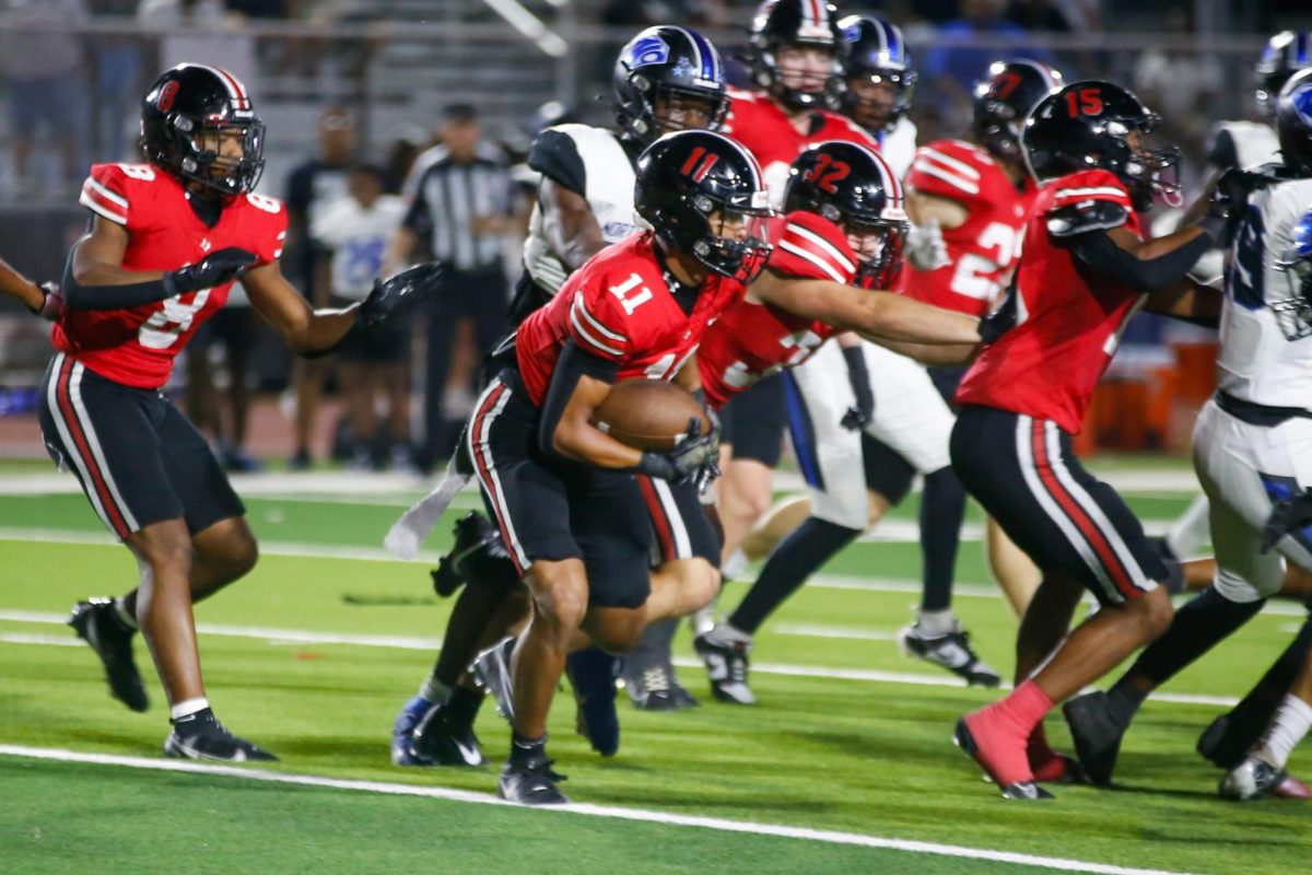 Junior running back no. 11 Daylan McCutcheon runs the ball up the field. The team had 36 rushing attempts.