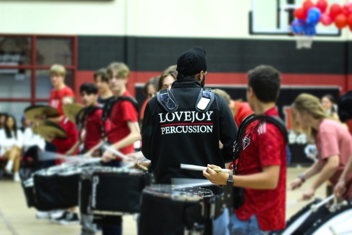 the Lovejoy Percussion leads the audiance in the cowbell chant. The band performed at halftime of the football game later that night. 