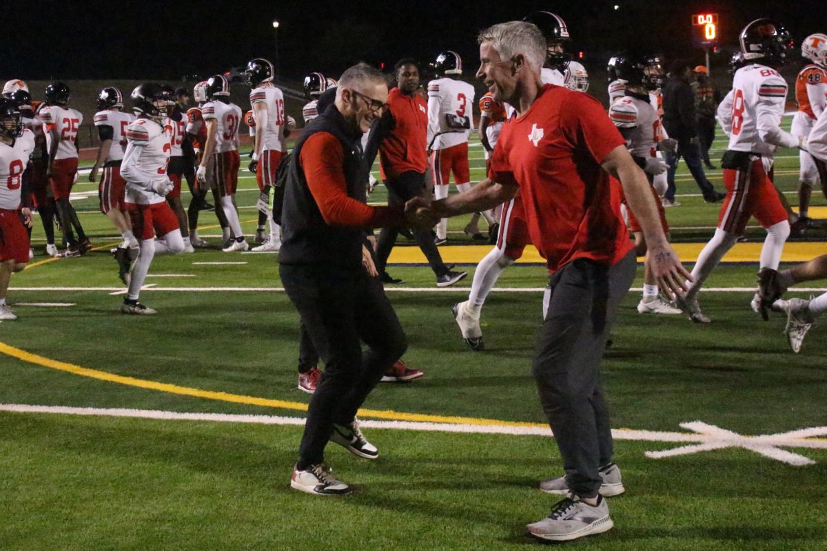 Football coaches Jayson Lavender and Jason Johns celabrate after a playoff victory. The team won 43-21.
