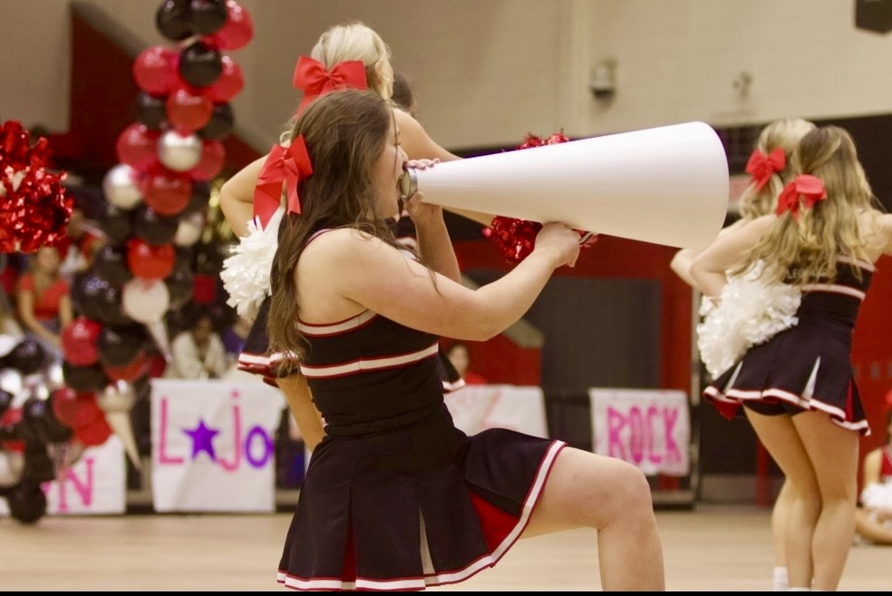 Senior cheer captain Addison Smith cheers with a megaphone at the pep rally. The pep took place on Friday, January 25th.