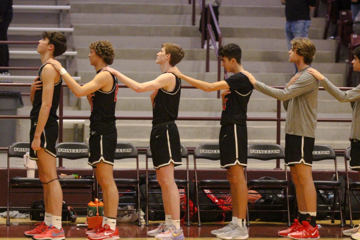 The boys team stands for the national anthem.  The team has a 7-11 record. 