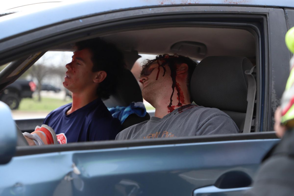 Senior Matthew Mainord and Kyle Branch sit in the car after the staged crash. Mainord passed away in the simulation.
