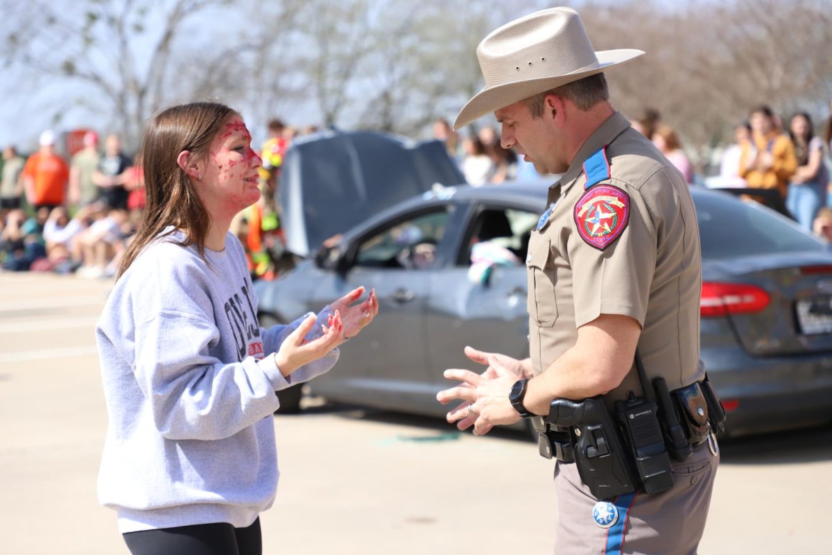 Junior Izzy Joyner talks to the officer after the staged crash. Joyner was arrested in the scene.
