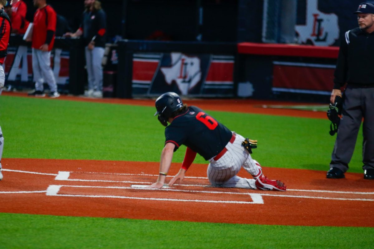 Junior third baseman no. 6 Asher Lacy slides into home. Lacy went 1-1 at the plate with a single to drive in a run.