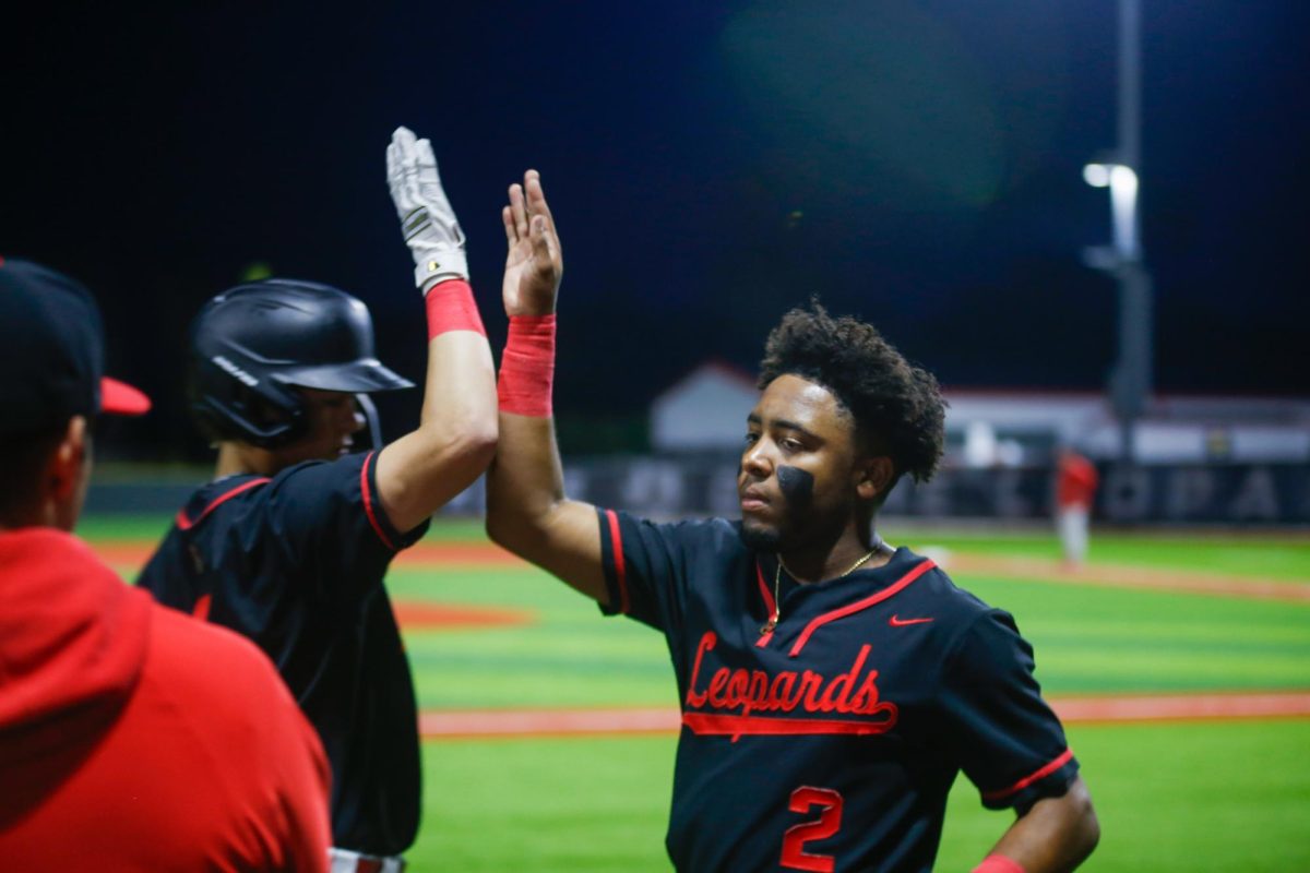 Senior second baseman no. 2 Aarren Marshall high fives a teammate. Marshall is committed to the University of Louisiana  Lafayette.