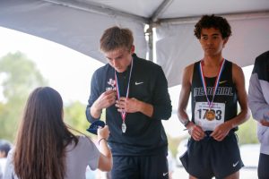 Junior Caden Gary receives his medal at the cross country regional meet. Gary recently broke three school records in track and field.