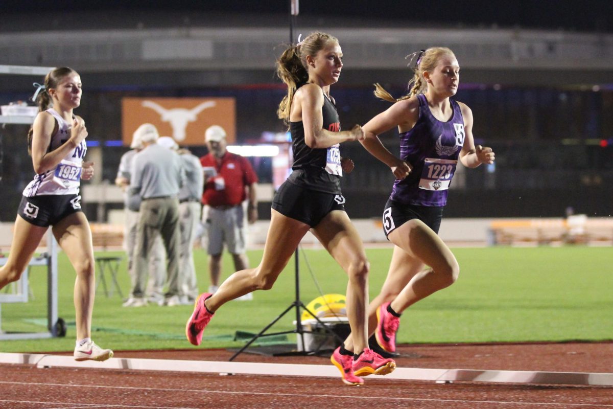Sophomore Camryn Benson passes a girl during the mile race. Benson ran a time of 5:01.21.