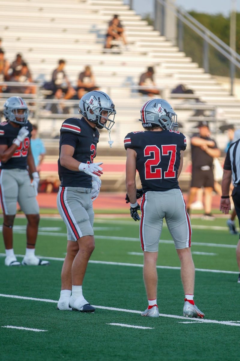 Senior Safety no. 3 RJ McIntosh high fives Junior corner no. 27 Taylor Pettit. Lovejoy played against Rockhill High School.