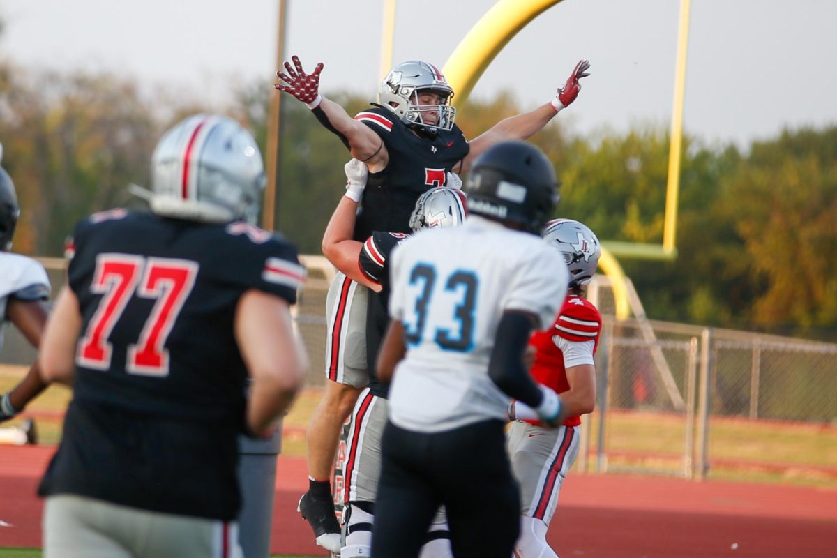 Senior guard no. 54 Braedon Gibson lifts Senior Running back no. 7 Ben Adams after a touchdown. The game was Olympic themed.