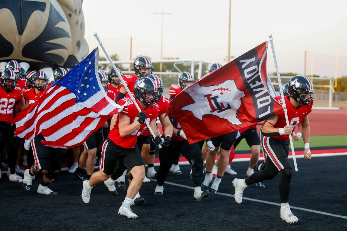 The team runs out of the tunnel before the game. The Lovejoy flag was carried by senior defensive lineman no. 9 Gavin Prince.