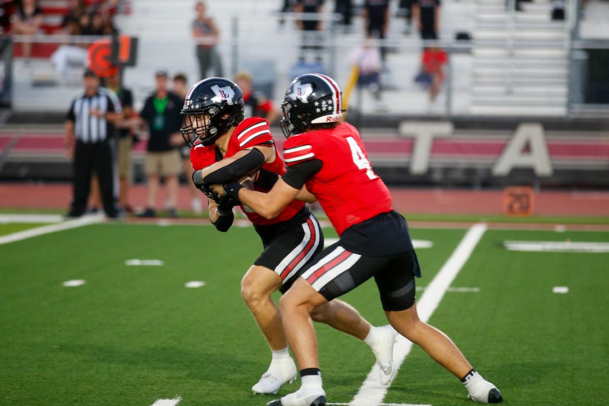 Junior quarterback no. 4 Jacob Janecek hands off the ball. Lovejoy is 1-0 in district.