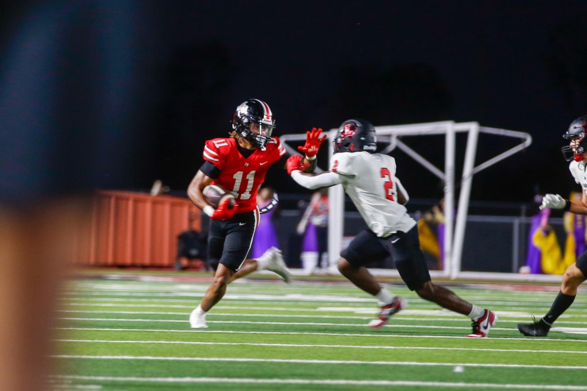 Senior wide receiver no. 11 Daylan McCutcheon returns a punt. The game was the Homecoming game.