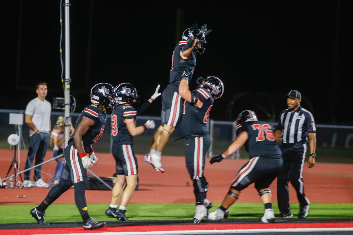 Senior guard no. 54 Braedon Gibson lifts another player to celebrate a touch down. The game was tied going with 10 seconds remaining.