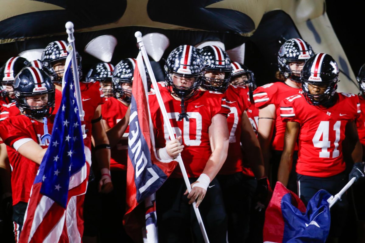 Junior offensive lineman no. 60 Major Smith carries the Lovejoy flag. Lovejoy played against Mansfield Timberview High School last Friday.