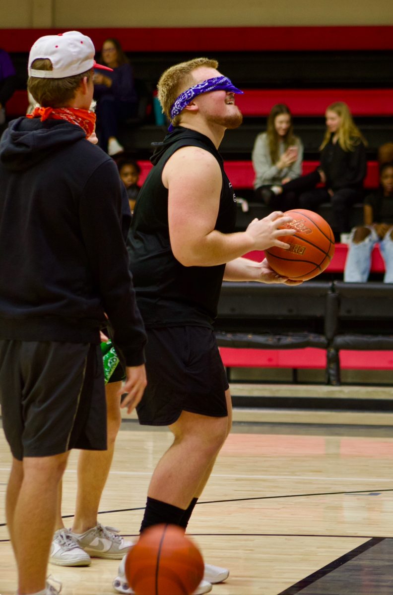 Senior Braedon Gibson prepares to shoot a blindfolded free throw. Gibson competed against four other students at halftime.